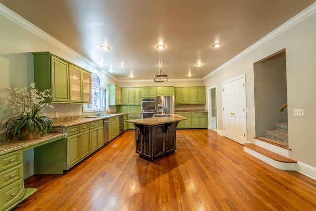 kitchen featuring stainless steel appliances, green cabinetry, a center island, and dark hardwood / wood-style flooring