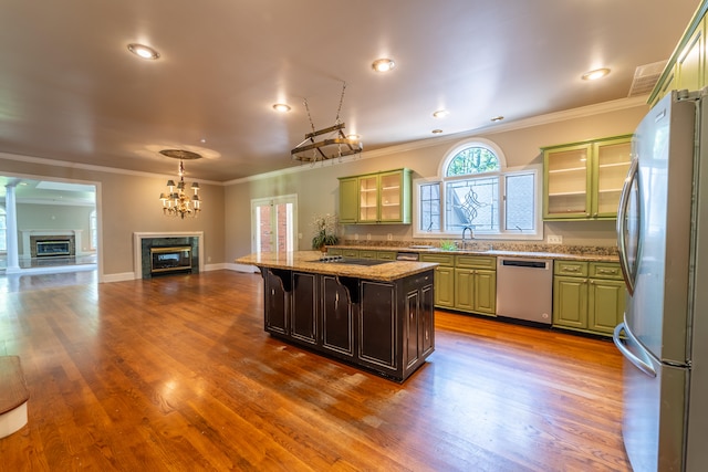 kitchen featuring wood-type flooring, a center island, a breakfast bar area, appliances with stainless steel finishes, and crown molding