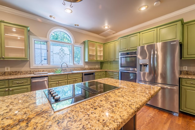 kitchen featuring ornamental molding, green cabinets, and appliances with stainless steel finishes