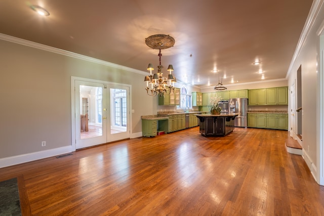 unfurnished living room with an inviting chandelier, hardwood / wood-style flooring, and crown molding