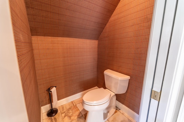 bathroom featuring lofted ceiling and toilet