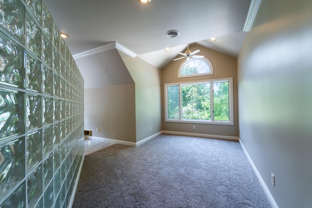 carpeted spare room with ceiling fan, lofted ceiling, and crown molding