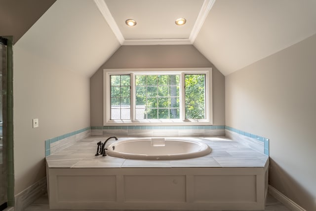 bathroom with ornamental molding, a tub to relax in, and vaulted ceiling