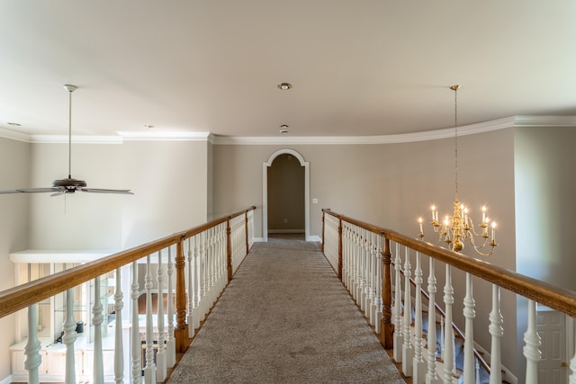 hallway with crown molding, carpet flooring, and an inviting chandelier