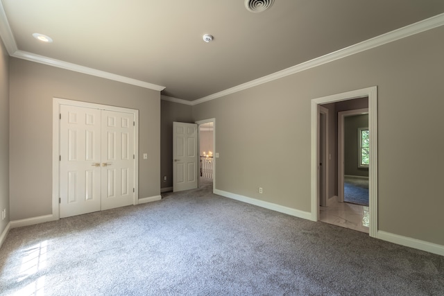 unfurnished bedroom featuring a closet, carpet floors, and crown molding