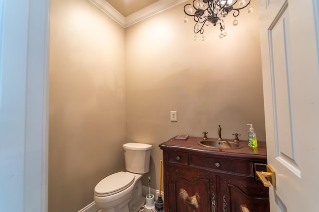 bathroom with ornamental molding, vanity, toilet, and a chandelier