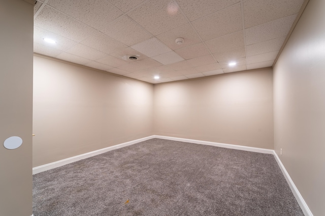 spare room featuring carpet floors and a paneled ceiling