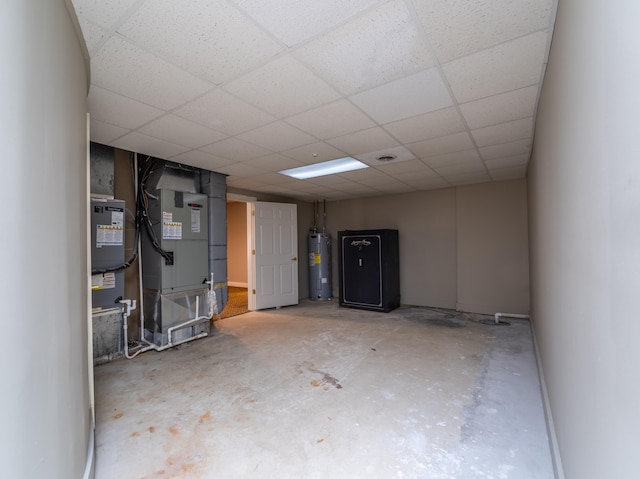 basement with a drop ceiling, heating unit, and electric water heater