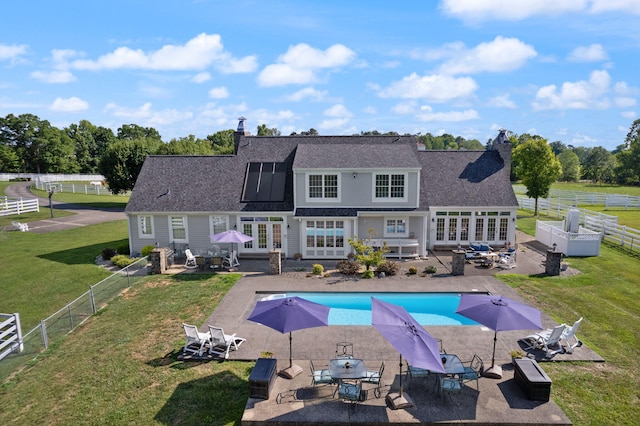 view of pool with french doors, outdoor dining area, a patio area, and a lawn