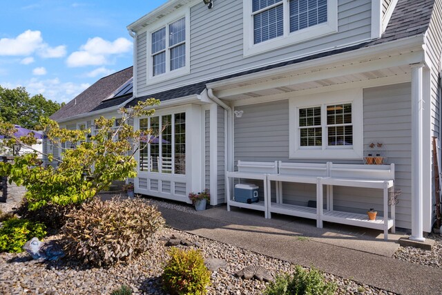 entrance to property featuring a shingled roof