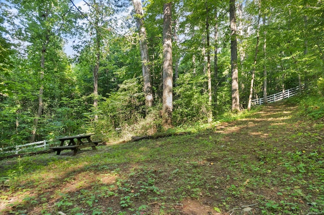 exterior space with a forest view and fence