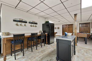 kitchen featuring a kitchen bar, a paneled ceiling, and black fridge