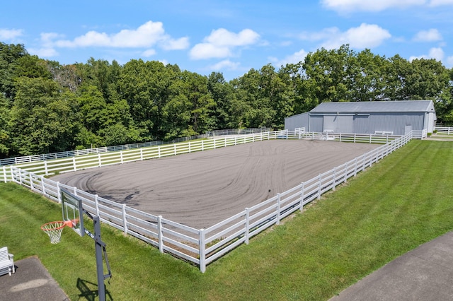 view of yard with a pole building, a rural view, an enclosed area, and an outbuilding