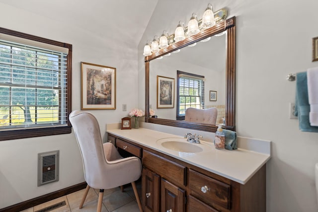 bathroom with tile patterned floors, vanity, and vaulted ceiling