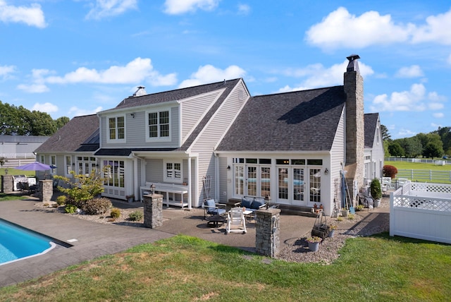 rear view of house featuring a lawn, a patio area, and french doors