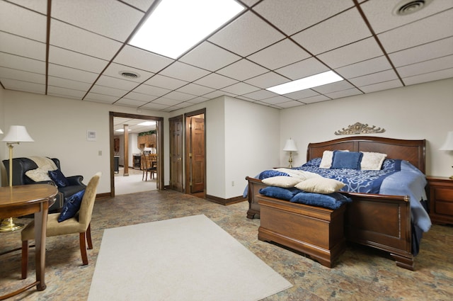 bedroom featuring baseboards, visible vents, and a drop ceiling