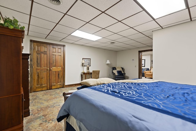 bedroom featuring a paneled ceiling and visible vents