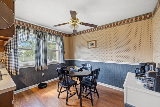 dining space with hardwood / wood-style flooring, ceiling fan, and a textured ceiling