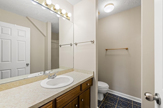 bathroom featuring vanity, toilet, and a textured ceiling