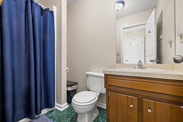 bathroom with vanity, toilet, and a textured ceiling