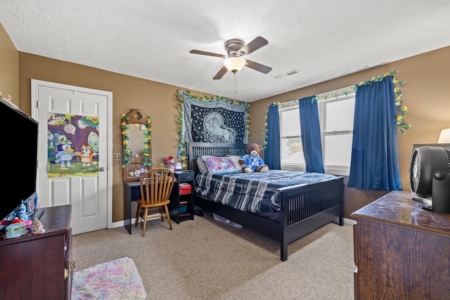 carpeted bedroom with a textured ceiling and ceiling fan