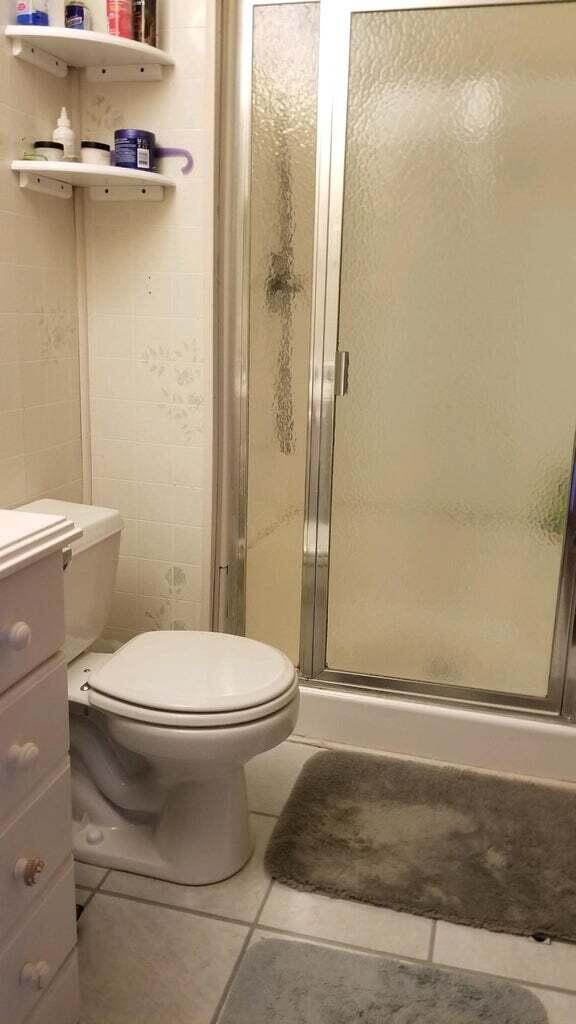 bathroom featuring tile patterned floors, a shower with shower door, vanity, and toilet