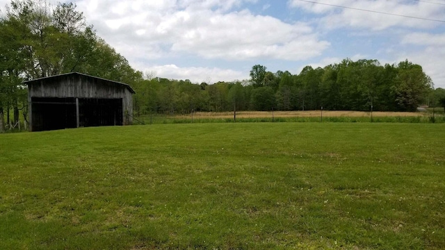 view of yard featuring a rural view and an outbuilding