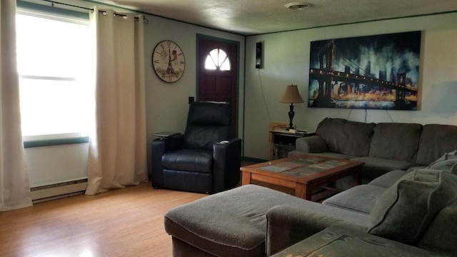 living room featuring light wood-type flooring and a baseboard heating unit