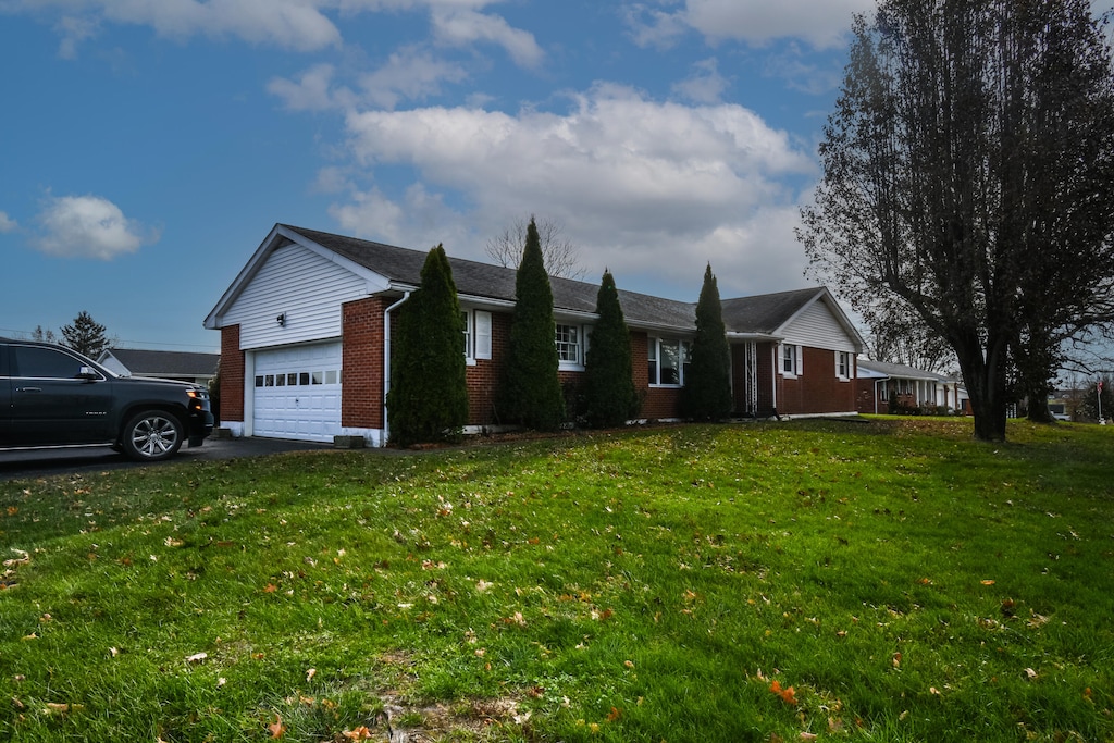 ranch-style home with a front yard and a garage