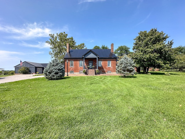 view of front of property with a front yard, brick siding, and a chimney