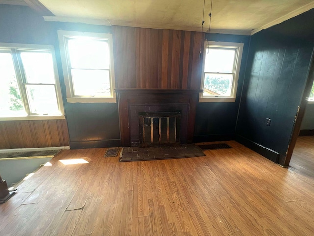 unfurnished living room featuring light hardwood / wood-style floors and crown molding
