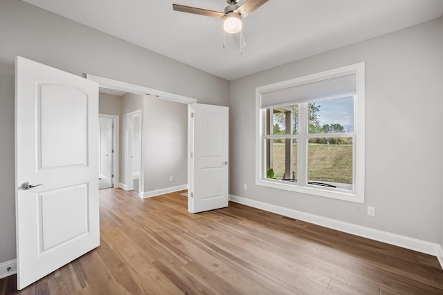 unfurnished bedroom featuring a ceiling fan, light wood-type flooring, visible vents, and baseboards