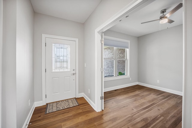 foyer featuring plenty of natural light, wood finished floors, a ceiling fan, and baseboards