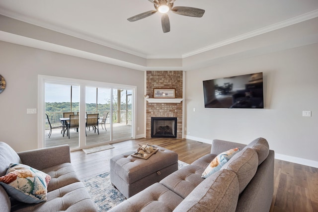 1830 Hunter Dr, Lancaster, KY 40444 - living room with a ceiling fan, ornamental molding, wood finished floors, baseboards, and a brick fireplace