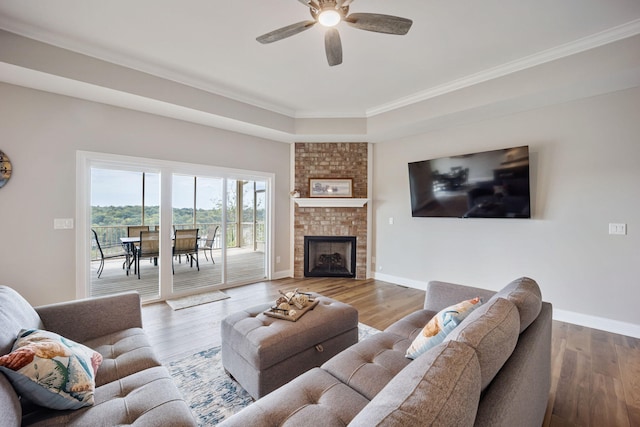 living room with a ceiling fan, baseboards, and wood finished floors