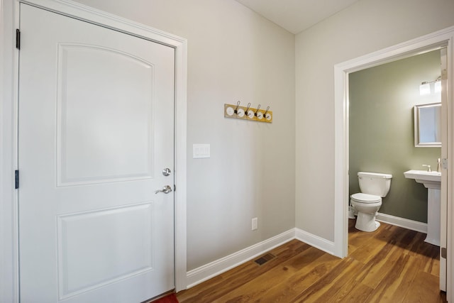 entryway with wood finished floors, visible vents, and baseboards