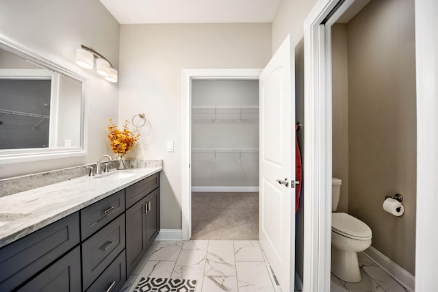 full bath with marble finish floor, vanity, toilet, and baseboards