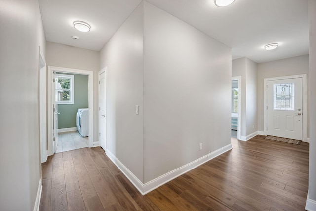 corridor with washer / clothes dryer and hardwood / wood-style floors