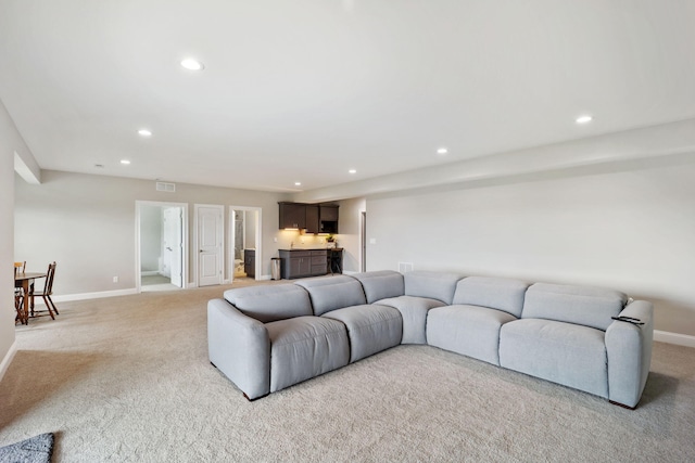 living area with recessed lighting, baseboards, and light colored carpet