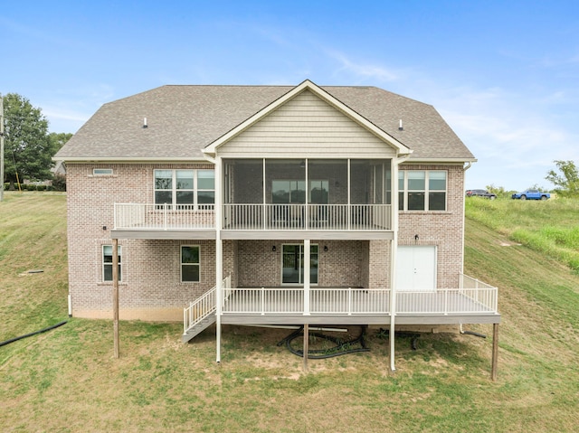 back of property with a shingled roof, a sunroom, brick siding, and a lawn