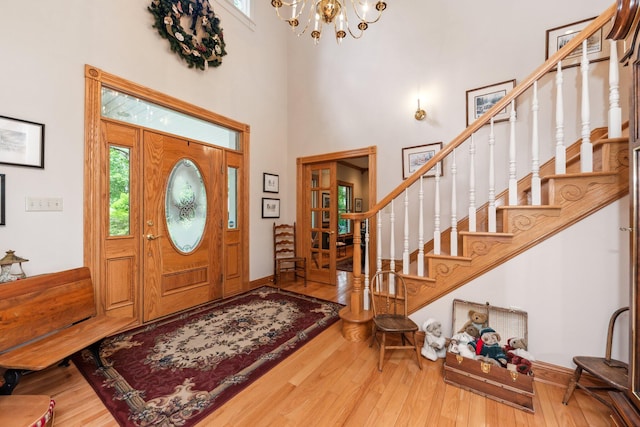 foyer entrance featuring a high ceiling, a chandelier, and hardwood / wood-style flooring