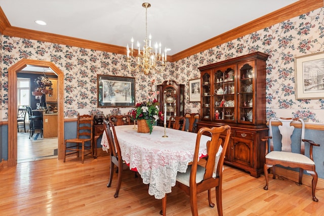 dining room with crown molding, light hardwood / wood-style flooring, and a chandelier