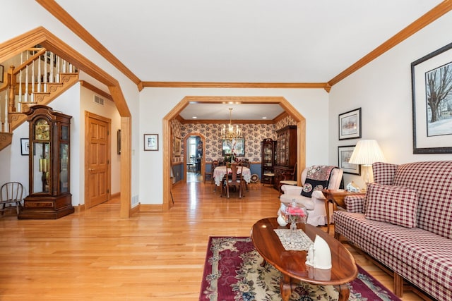 living room featuring crown molding, hardwood / wood-style flooring, and a notable chandelier