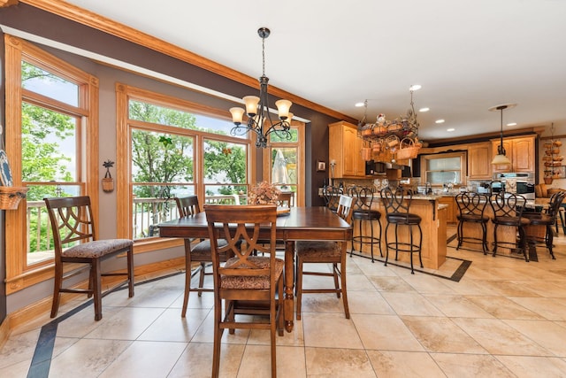 dining area with crown molding, plenty of natural light, an inviting chandelier, and light tile patterned floors