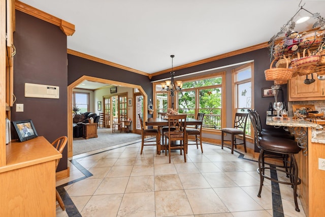 tiled dining area featuring a chandelier and ornamental molding