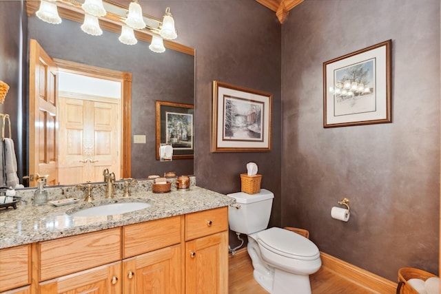 bathroom featuring toilet, hardwood / wood-style flooring, crown molding, and vanity