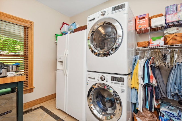 washroom with light tile patterned floors and stacked washer and dryer