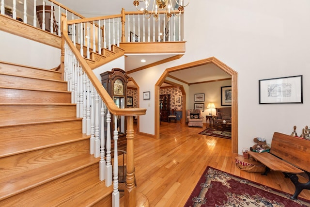 foyer with crown molding, hardwood / wood-style flooring, and a chandelier