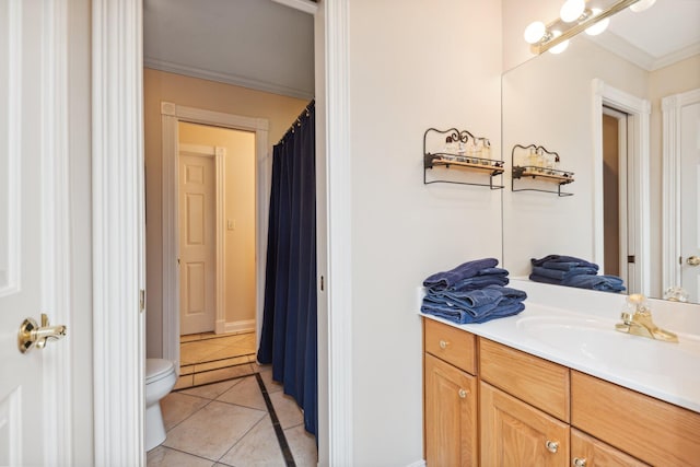 bathroom with crown molding, vanity, toilet, and tile patterned flooring