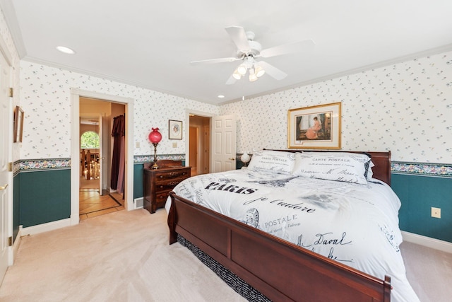 carpeted bedroom with ornamental molding and ceiling fan